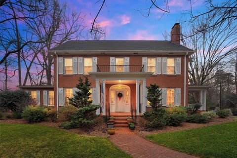 Enjoy the warm and inviting ambiance of the home’s front view beautifully lit at night.