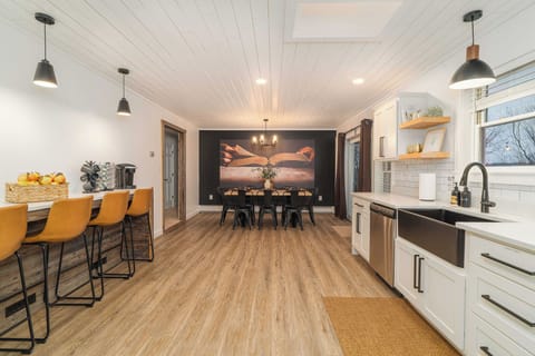 Open-Concept Kitchen with Bar Seating & Large Dining Table. A welcoming space designed for cooking, gathering, and sharing meals together.