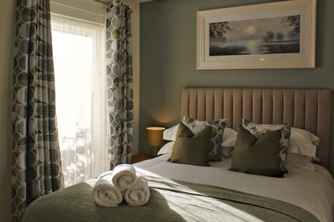 The master bedroom boasts an en-suite, with plush bedding and stylish decor.