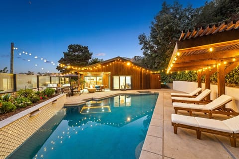 Inviting twilight oasis with glowing string lights and chic loungers.