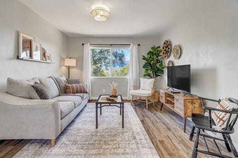 Settle into your beautifully appointed living space where modern comfort meets warm natural touches. Sink into the plush sofa while enjoying tree-lined views through bright windows, or catch up on your favorite shows on the flat-screen TV after a day of ex