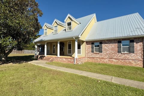 A well-kept lawn and mature tree frame the property, enhancing its cozy suburban charm.