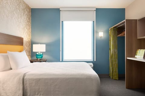 Drift off in crisp linens beside warm, glowing bedside light.