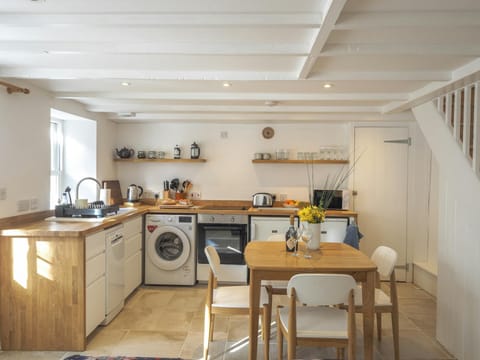 Floor cabinets, washing machine, oven, sink, table and chairs