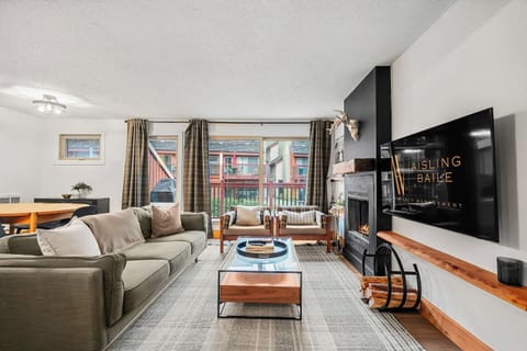 Main floor living room with a 55` Smart TV with cable, board games, cozy seating options, and a decorative fireplace for that cabin ambiance (3-hour glow logs only please!)