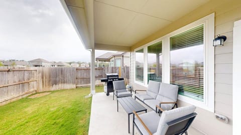 Fully fenced backyard with grill and comfortable outdoor seating