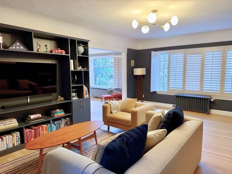 Main living space65" OLED tv with 4K AppleTV, original 1926 flooring, and beautiful light from banks of windows!