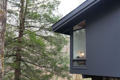 Single-level mid-century masterpiece perched above the rushing Clay Brook