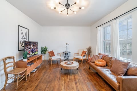 Living Area with a leather couch, two lounge chairs, and a smart TV, perfect for catching up on your favorite shows.