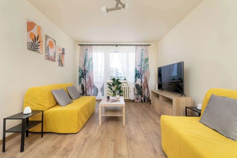 Bright living room with large window and comfortable seating.
