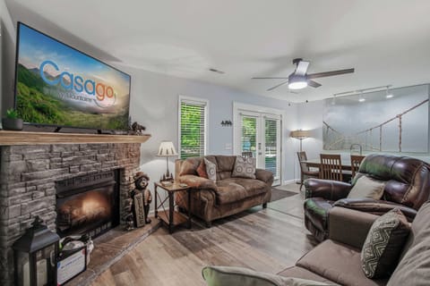 Stone fireplace with TV above, perfect focal point for cozy cabin nights. Ideal for couples and winter getaways.