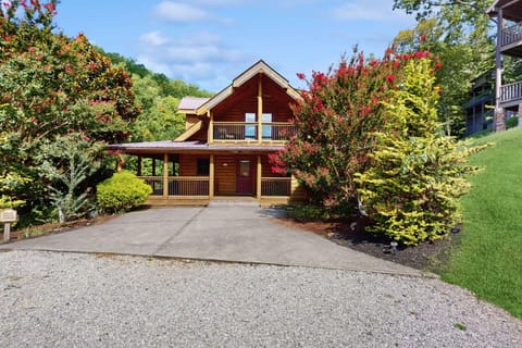 Charming Smoky Mountain log cabin with covered porch, private driveway parking, and lush landscaping. Perfect for a Gatlinburg & Pigeon Forge getaway, family vacation, or romantic weekend retreat.