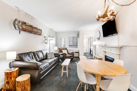 Spacious open-concept living room with cozy leather sofa, recliner, electric fireplace, smart TV, and rustic mountain décor. Perfect for relaxing after exploring Gatlinburg, Pigeon Forge, and the Smoky Mountains. Ideal for couples or small families.