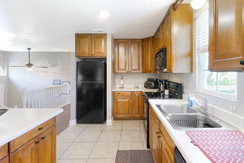 Bright kitchen with double sink, dishwasher, microwave, and full-size fridge. Ready for long stays and family vacations; stocked cooking space, clean counters, and easy flow to dining and living areas.