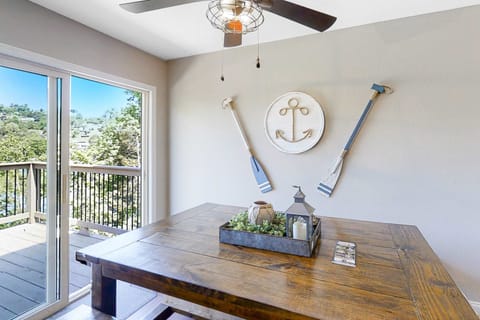 Dining space with large table and sliding doors to the deck. Ideal for meals and gatherings; easy indoor/outdoor flow, lake views, and bright natural light for family vacations and group stays.