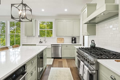 Fully stocked gourmet kitchen with oversized island, gas range, custom cabinetry, and modern appliances. Ideal for family meals, group cooking, and lake house entertaining.