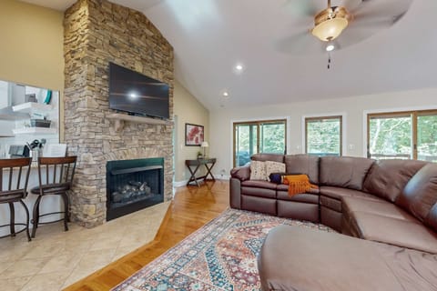 Gather around the stone fireplace and enjoy nature views through expansive windows!