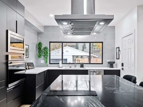 Bright kitchen view w/ large window & smooth, open counter space.