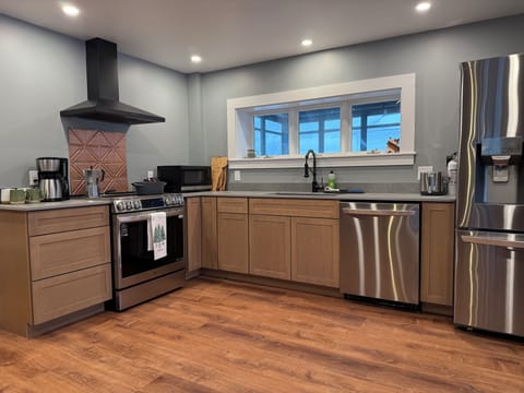 New kitchen with wood cabinets and stainless steel appliances.
