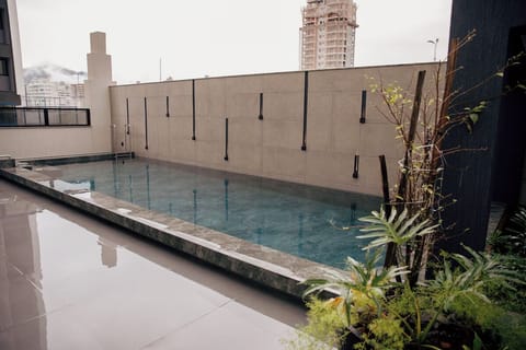 Float peacefully in a quiet courtyard pool framed by skyline.