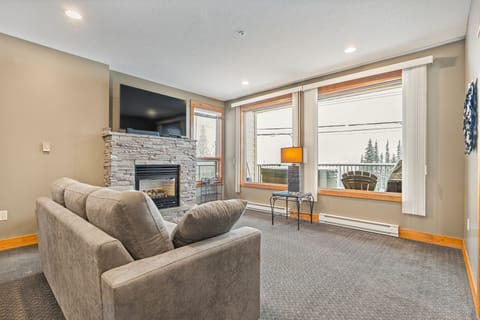 The living room features a pull out bed and fireplace, along with a beautiful view.