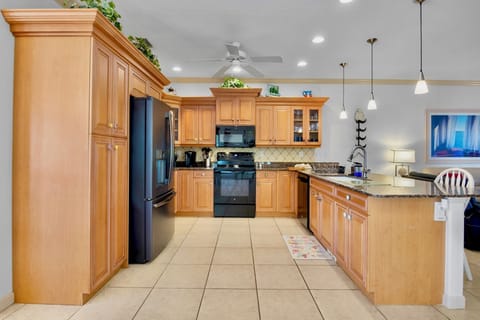 Your spacious kitchen features warm wood cabinets, granite counters, and modern appliances for preparing memorable meals together.