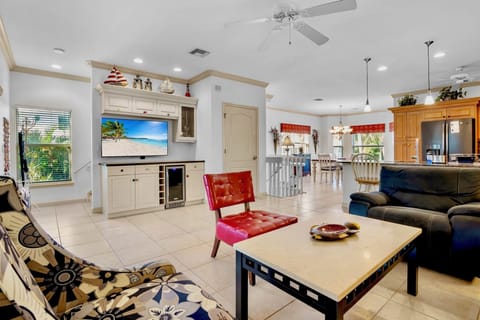 Relax in your spacious open-plan living area with comfortable seating, entertainment center, and tropical beach vibes throughout.