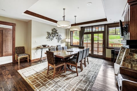 Bright dining space with floor-to-ceiling windows and rustic wood accents, perfect for gathering over mountain-view breakfasts or après-ski dinners.