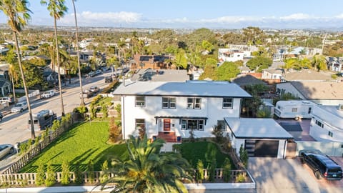 Aerial view of the home with a large yard and bright two-story exterior.