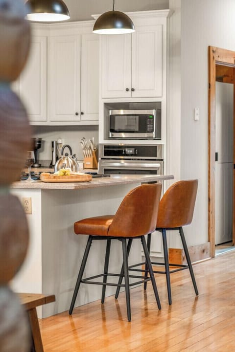 Gather for meals in the dining area with rustic cabin charm, plenty of seating, and natural light pouring in from the windows.