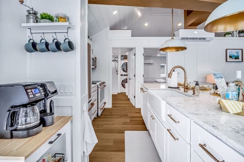 Large modern kitchen includes island counter with deep farmhouse sink