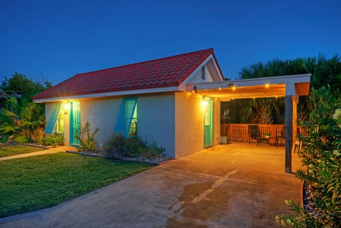 Charming coastal cottage with a cozy, well-lit patio perfect for relaxing after a day at the beach.