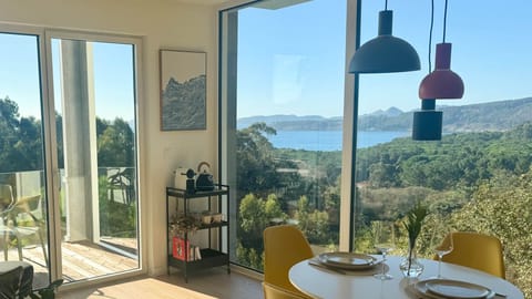 Living-dinning area with floor to ceiling windows and sea view