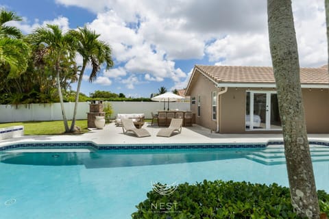 Spacious backyard oasis with a luxurious saltwater pool and pool cage for privacy.