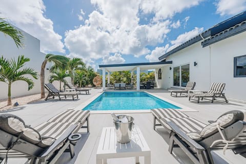 Daytime pool view with sun loungers and open skies, designed for all-day outdoor enjoyment.