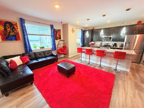 Open-concept lounge + kitchen with cozy sectional and island seating—perfect for group hangs.
