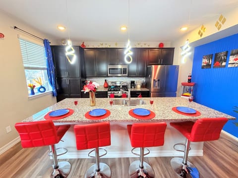 Modern kitchen + granite island with stainless appliances and bar seating for four.