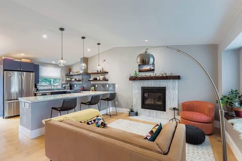 A modern kitchen with a seating area featuring a warm fireplace, creating a cozy spot to enjoy meals, coffee, or conversation. Perfect for relaxing and entertaining in a bright, open space.