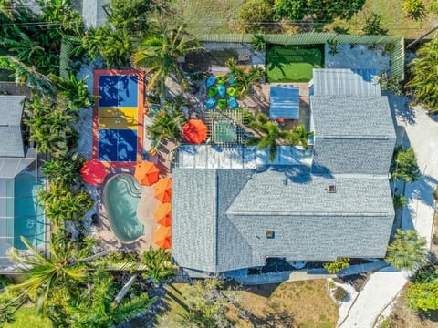 Drone view of Bradenton’s ultimate stay—pool, pickleball court, hot tub, fire pit, outdoor movie theater, bar, and backyard mini golf all in one epic getaway