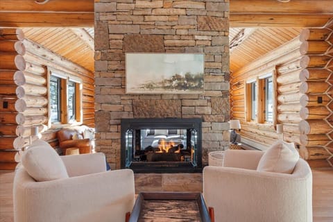 Living room (main floor): Gas fireplace, Smart TV, vaulted ceilings, forest views