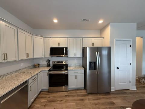 A modern, sunlit kitchen featuring stainless steel appliances, ample counter space, and everything you need for a hassle-free stay.