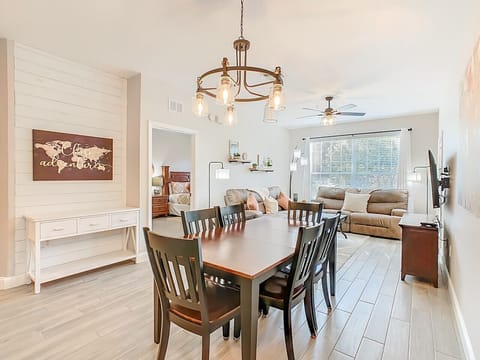 Bright open-concept living and dining space with comfortable seating and a large TV for family relaxation