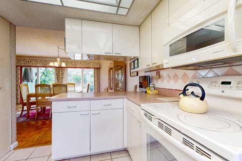 Enjoy an open coastal kitchen and dining layout designed for an easy beach stay. Prepare meals while staying connected with family and friends, making it perfect for laid-back gatherings after a day at the beach.