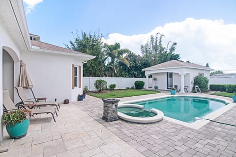 Enjoy a resort-style backyard with a sparkling pool, spa, and sun loungers—perfect for a relaxing beach stay. Unwind poolside, soak up the Florida sunshine, and recharge after a day at the beach.