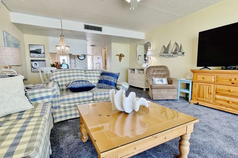 Unwind in this spacious, beach-inspired living room featuring comfortable seating, coastal décor, and a flat-screen TV—perfect for relaxing together after a sun-filled day at the beach during your beachfront vacation stay.