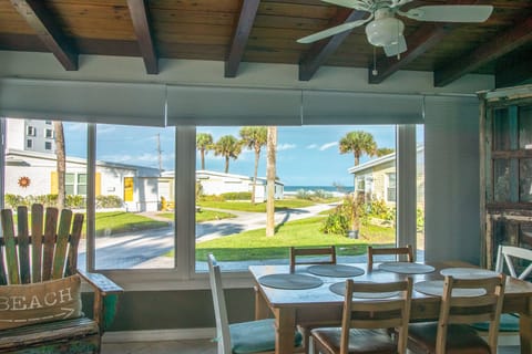 Enjoy meals in this bright dining area with large windows overlooking lush grounds and palm trees. A relaxing spot to gather, soak in coastal light, and savor every moment of your beach stay.