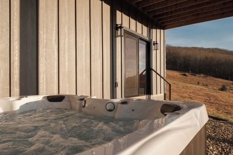 Enjoy a private hot tub tucked beneath the deck, offering shade, privacy, and relaxing mountain views.