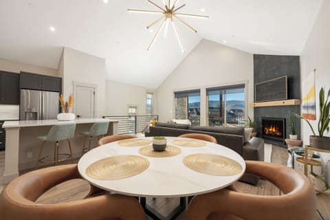 Unwind in your stunning open-concept living space where modern elegance meets cozy comfort, featuring a crackling fireplace and mountain views.