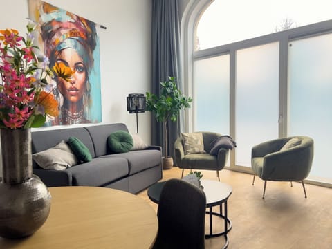 Cozy seating area with modern sofa in this Goirkestraat apartment – unwind after a day in Tilburg.