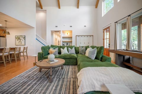 Bright windows, warm wood tones, and a cozy green sectional create the perfect retreat for connection. ✨🌲